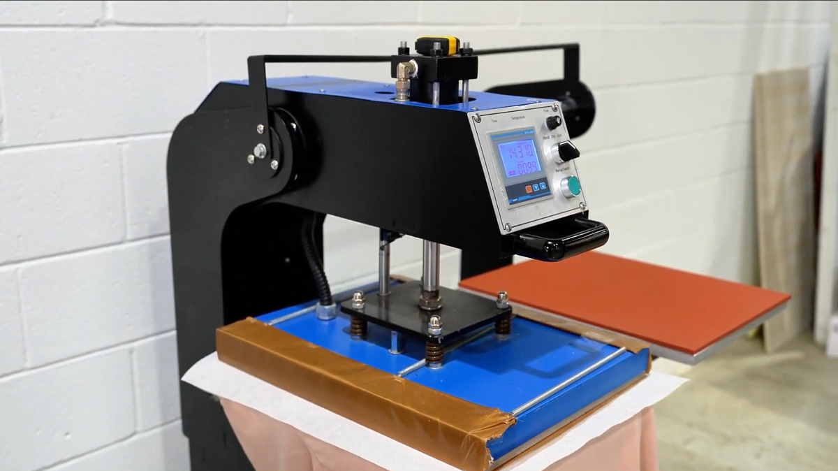 Carrier film being peeled from a DTF print on a charcoal garment